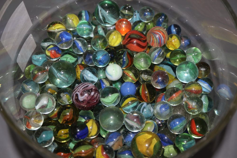 A glass jar and cover containing Victorian and later coloured marbles, height 26.5cm